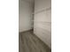 Walk-in closet with wood-style flooring and white, wall-mounted wire shelving at 18441 Round O Rd, Round O, SC 29474