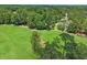 Aerial view of a lush golf course highlighting a creek, mature trees, and pristine greens at 195 Prestwick Ct, Summerville, SC 29483