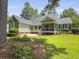 Expansive backyard with manicured lawn, mature trees, and inviting screened porch for outdoor enjoyment at 195 Prestwick Ct, Summerville, SC 29483