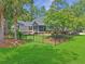 Lush backyard featuring mature landscaping, a manicured lawn, and black fence for added privacy at 195 Prestwick Ct, Summerville, SC 29483