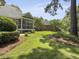 Spacious backyard featuring lush landscaping, a charming patio, and a screened-in porch at 195 Prestwick Ct, Summerville, SC 29483