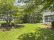 Lush backyard with green lawn, mature trees, and a screened-in porch for relaxing outdoors at 195 Prestwick Ct, Summerville, SC 29483