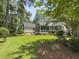 Beautiful backyard featuring a well-kept lawn, mature landscaping, and a screened porch at 195 Prestwick Ct, Summerville, SC 29483