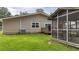 A screened porch is attached to the home, with grassy backyard, ready for relaxing at 212 Kentucky Dr, Ladson, SC 29456
