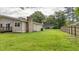 Spacious backyard featuring a large grassy area, brick chimney, and a wooden fence at 212 Kentucky Dr, Ladson, SC 29456