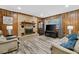 Cozy living room featuring a brick fireplace, wood-paneled walls, and stylish flooring at 212 Kentucky Dr, Ladson, SC 29456