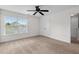 Bright, empty bedroom with a ceiling fan, carpet, and a view of neighboring homes at 213 Crossandra Ave, Summerville, SC 29483
