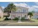 Charming two-story home with a well-maintained lawn, palm trees, and a welcoming front porch at 213 Crossandra Ave, Summerville, SC 29483