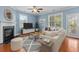A staged living room with a fireplace, wood floors, neutral furniture and a ceiling fan at 213 Crossandra Ave, Summerville, SC 29483