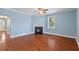 A living room with blue walls, wood floors, fireplace, and window with blinds at 213 Crossandra Ave, Summerville, SC 29483