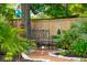 Secluded backyard garden area features an ornate bench, lush plants and a brick path at 217 7Th Ave, Mount Pleasant, SC 29464