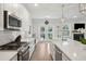 Bright white kitchen with stainless steel appliances, a large island, and French doors to outdoor space at 217 7Th Ave, Mount Pleasant, SC 29464
