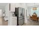 View of the stainless steel refrigerator and the breakfast area featuring light-colored walls and hardwood floors at 217 7Th Ave, Mount Pleasant, SC 29464