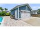 Detached garage with white door, blue siding, and stylish brick paver driveway near lush greenery and a pool at 2219 Kemmerlin St, Johns Island, SC 29455