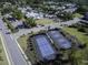 Aerial view showcasing community amenities, including tennis courts and a swimming pool, surrounded by lush greenery at 2241 Dewees Creek Dr, Mount Pleasant, SC 29466