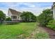 Spacious backyard featuring a well-maintained lawn, mature trees, and a trampoline for recreational activities at 2241 Dewees Creek Dr, Mount Pleasant, SC 29466