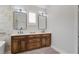 Bright bathroom featuring double sinks, quartz countertop, wood cabinetry, and modern lighting fixtures at 2241 Dewees Creek Dr, Mount Pleasant, SC 29466