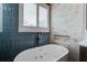 Stylish bathroom featuring a luxurious soaking tub, sleek black fixtures, and elegant marble and blue tile accents at 2241 Dewees Creek Dr, Mount Pleasant, SC 29466