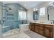 Bright bathroom with a glass shower stall, freestanding bathtub, and wood cabinets with double sinks at 2241 Dewees Creek Dr, Mount Pleasant, SC 29466