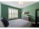 A bedroom features hardwood floors, a green accent wall, and a large window at 2241 Dewees Creek Dr, Mount Pleasant, SC 29466
