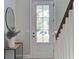 Bright foyer with a white door and a tasteful round mirror decorates the entrance at 2241 Dewees Creek Dr, Mount Pleasant, SC 29466