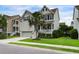 Charming two-story home with a well-manicured lawn, a palm tree, and a welcoming front porch at 2241 Dewees Creek Dr, Mount Pleasant, SC 29466