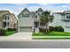 Attractive two-story home featuring a well-kept lawn, a palm tree, and an inviting front entrance at 2241 Dewees Creek Dr, Mount Pleasant, SC 29466