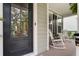 Inviting front porch with rocking chairs, complemented by stylish black door and hardware at 2241 Dewees Creek Dr, Mount Pleasant, SC 29466
