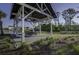 Community gazebo with picnic tables overlooking a pond, surrounded by lush landscaping and mature trees at 2241 Dewees Creek Dr, Mount Pleasant, SC 29466