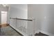 Hallway with wooden handrail, white walls, and view to bathroom with bathtub and shower at 2241 Dewees Creek Dr, Mount Pleasant, SC 29466