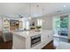 Bright kitchen island with pendant lights, adjacent to a living area and an outdoor patio at 2241 Dewees Creek Dr, Mount Pleasant, SC 29466