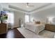 Main bedroom featuring a neutral color scheme, tray ceiling, ceiling fan, and hardwood floors at 2241 Dewees Creek Dr, Mount Pleasant, SC 29466
