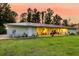 Expansive backyard view featuring covered patio and fire pit surrounded by mature trees at 242 Cheyenne Rd, Summerville, SC 29483