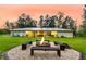 Spacious backyard with fire pit, bench seating, and expansive lawn at 242 Cheyenne Rd, Summerville, SC 29483