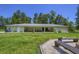 Large backyard with covered patio, lush lawn, fire pit, and wooded perimeter at 242 Cheyenne Rd, Summerville, SC 29483
