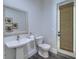 Updated powder room with pedestal sink, decorative mirror, and door to backyard at 242 Cheyenne Rd, Summerville, SC 29483
