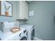 Efficient laundry room with modern appliances, a storage cabinet, and stylish decorations for a functional space at 246 Slipper Shell Ct, Mount Pleasant, SC 29464
