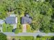An aerial view of the property showcasing its layout, roof, driveway, and landscaping, surrounded by lush trees at 261 Palm St, Mount Pleasant, SC 29464