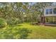 Lush backyard featuring a well-manicured lawn, mature trees, and an outdoor seating area with stairs to the house at 261 Palm St, Mount Pleasant, SC 29464