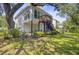 Backyard view of the home featuring a private deck, spacious patio, and mature landscaping at 261 Palm St, Mount Pleasant, SC 29464