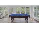 Bright game room features a well-lit billiards table and expansive windows overlooking the lush yard at 261 Palm St, Mount Pleasant, SC 29464