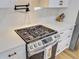 Close-up of a gas range with custom hood and tiled backsplash in a modern kitchen at 261 Palm St, Mount Pleasant, SC 29464
