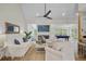 Bright living room with white sofas, a fireplace, and a view into a game room at 261 Palm St, Mount Pleasant, SC 29464