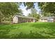 Backyard view showing the back of the house with lush lawn and detached garage at 267 Industrial Rd, Walterboro, SC 29488