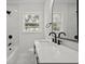 Bright bathroom with white marble walls, black hardware, and a large mirror at 267 Industrial Rd, Walterboro, SC 29488