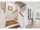 Elegant staircase featuring hardwood steps, white risers, wooden handrail, and decorative wall art at 2815 Colonel Harrison Drive Dr, Johns Island, SC 29455