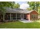 Backyard view of a home with a screened patio, a grill, and a stone patio at 2941 Murraywood Rd, Johns Island, SC 29455