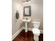 Powder room featuring a pedestal sink with decorative mirror and dark wood flooring at 2941 Murraywood Rd, Johns Island, SC 29455