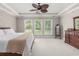 A spacious primary bedroom featuring neutral-toned walls and carpeting, a ceiling fan, and wood furniture at 2941 Murraywood Rd, Johns Island, SC 29455