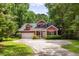 Charming two-story red home featuring a well-manicured lawn and an attached garage at 2941 Murraywood Rd, Johns Island, SC 29455
